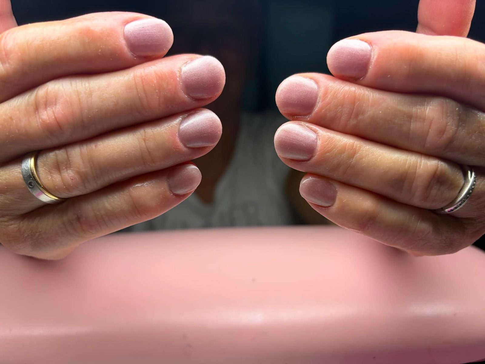 Korte nude nagels met ringen, van dichtbij