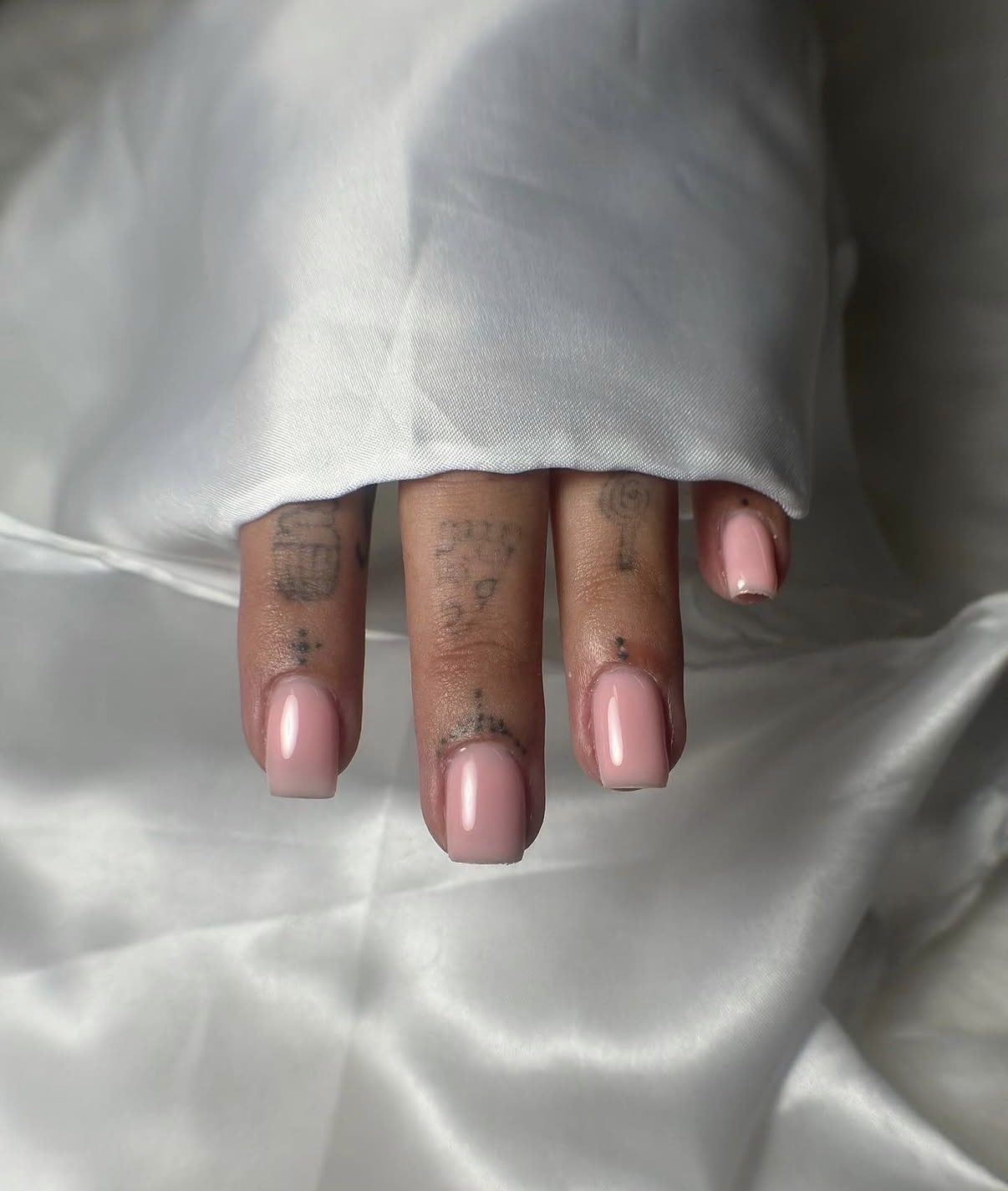 Nude roze nagels op wit satijn
