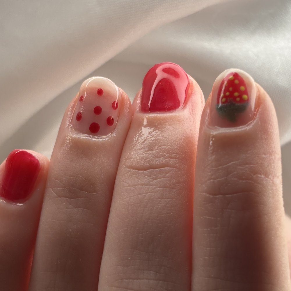 Rode nail art met witte stippen en een aardbei