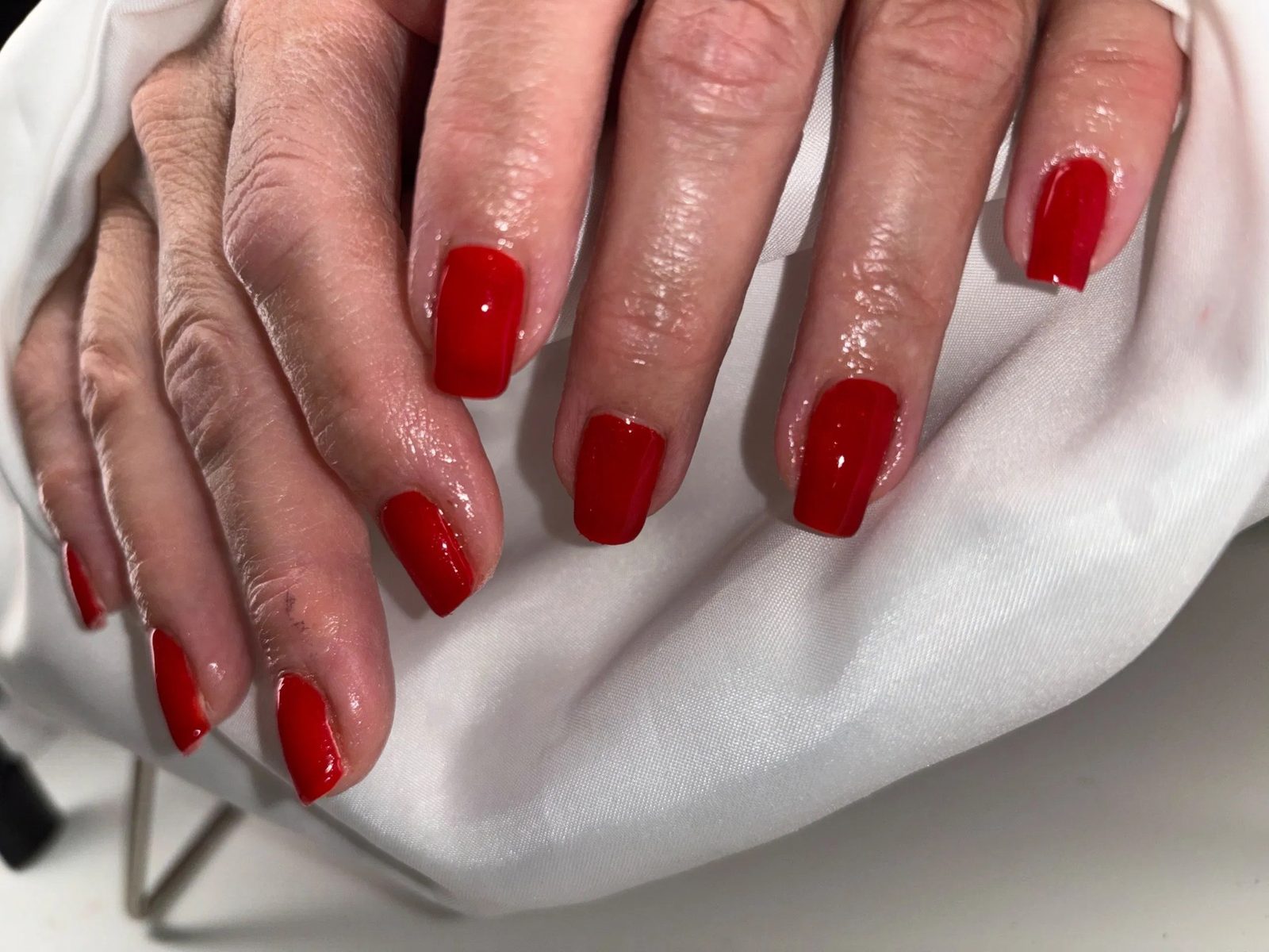 Rode vierkante nagels op wit satijn