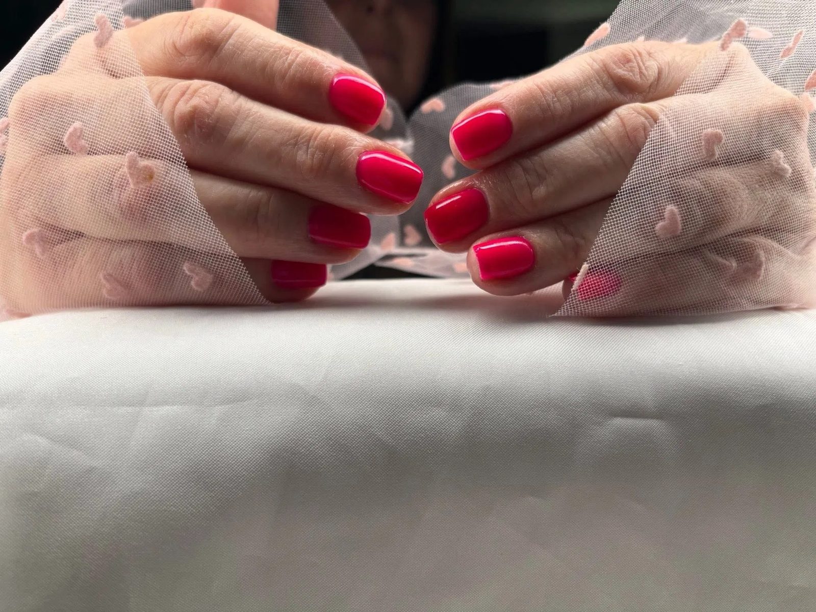 Frambozenrode nagels op satijn met kant