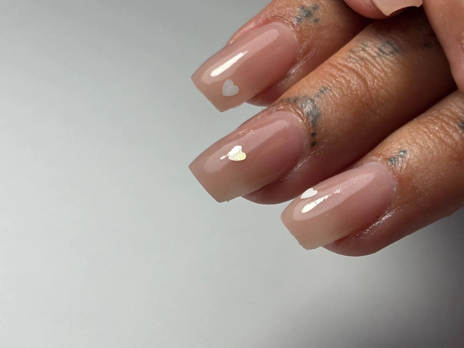 Nude glanzende nagels met een klein hartje