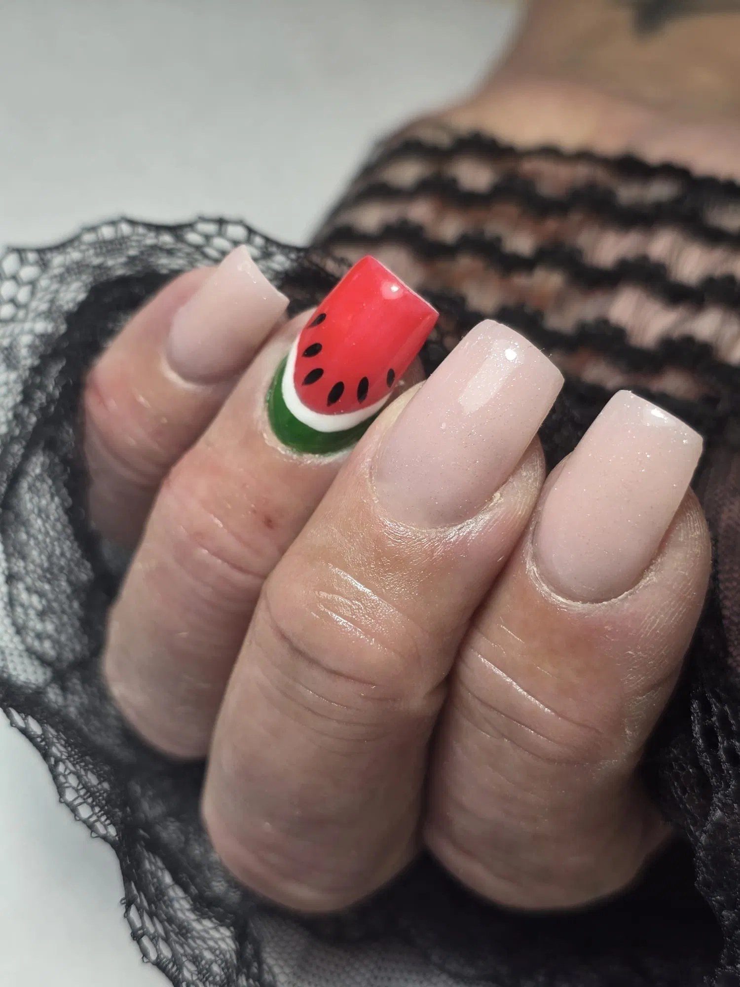 Nude vierkante nagels met een watermeloen als nail art